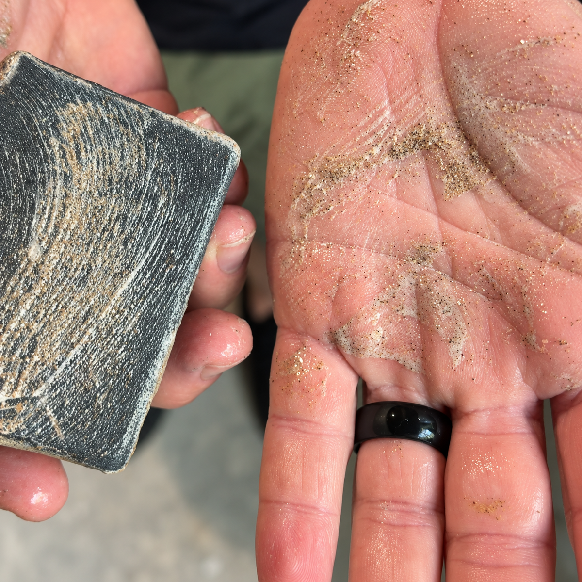 Bar of Shop Soap, a dark charcoal soap bar with visible walnut grit texture.